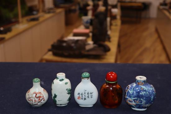 Four 19th century porcelain snuff bottles and an inside painted amber glass snuff bottle